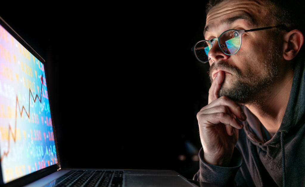 a man analyzing stock market charts, financial data on an electronic board.